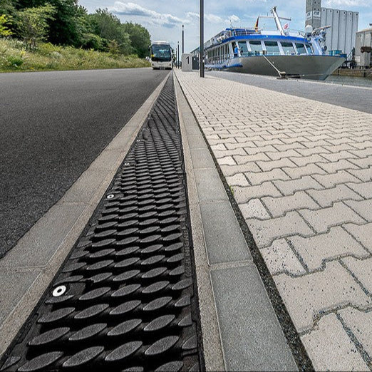 An industrial drainage grate system supplied by Northstar Industries on a pedestrian roadway